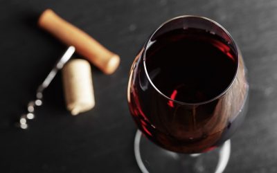 wine glass of red wine with a corkscrew.